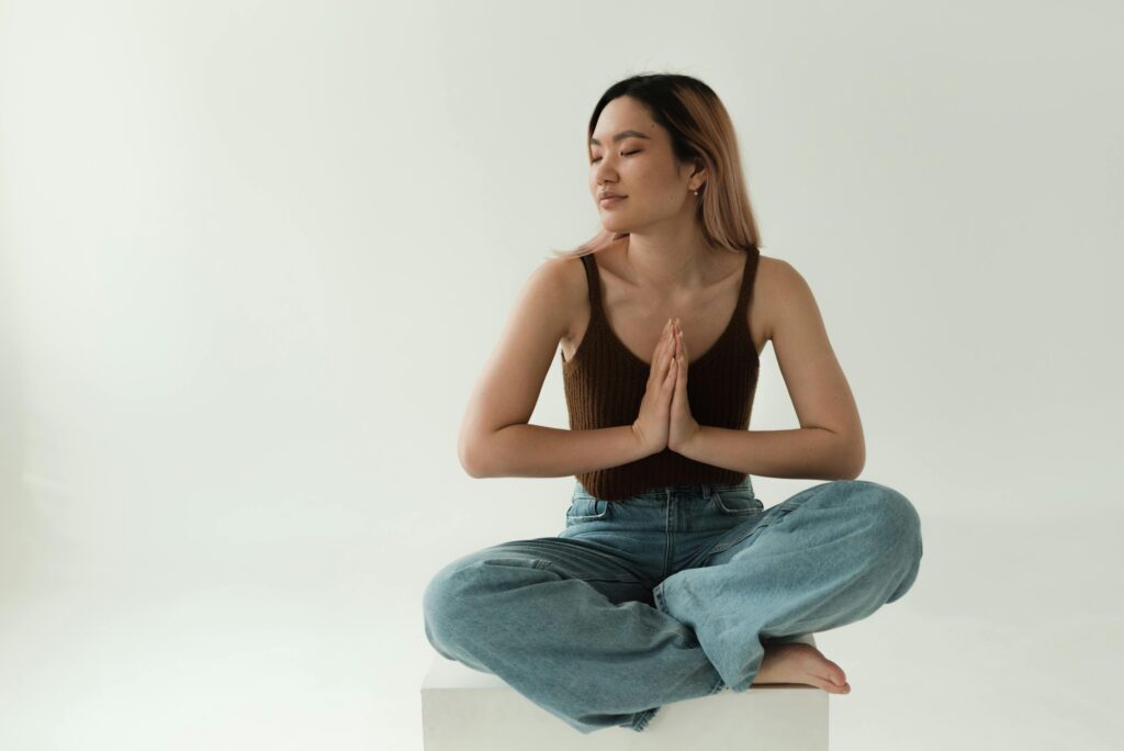 Primer plano de persona meditando con su manos relajadas haciendo un mudra con respiración profunda.